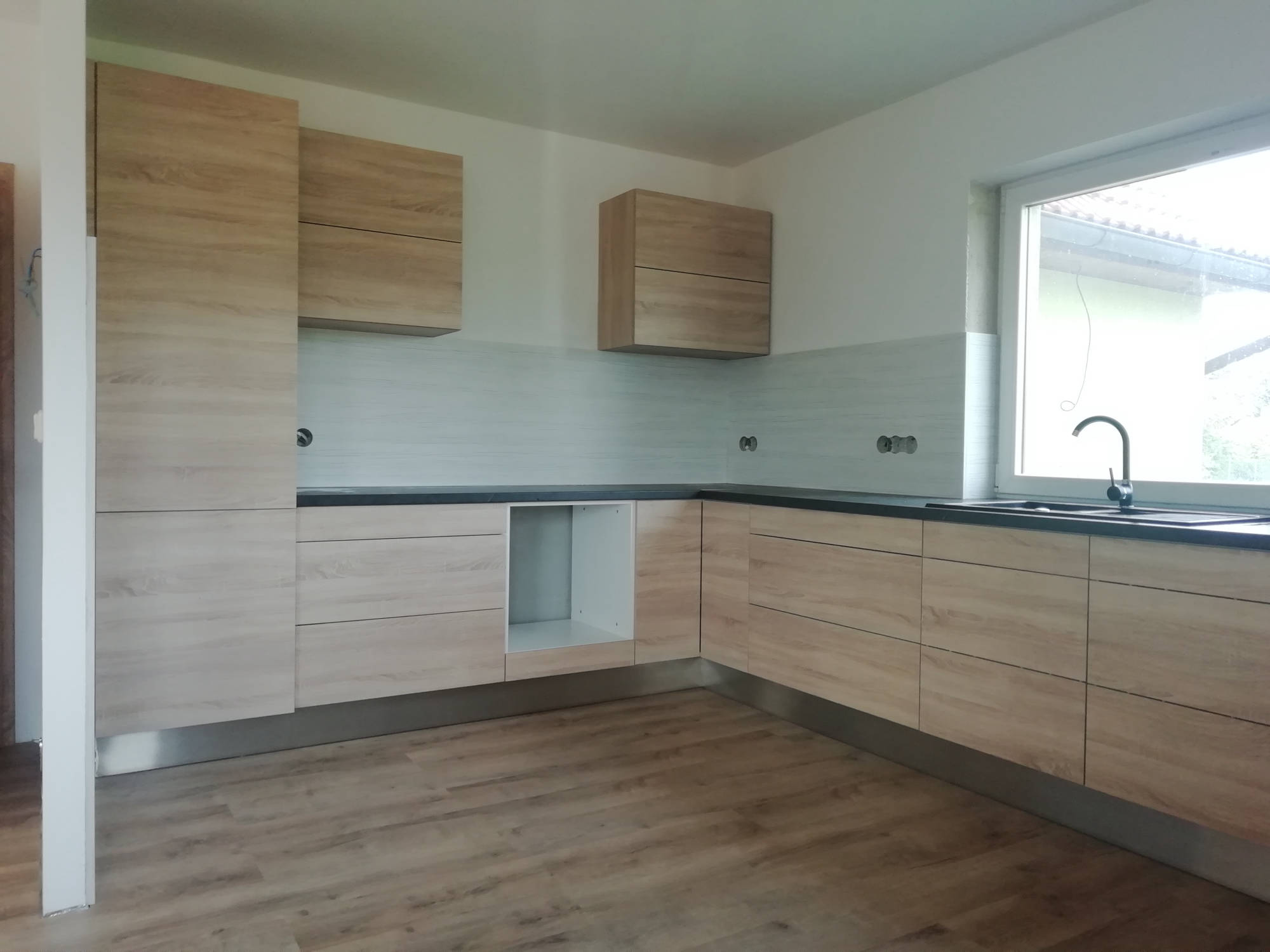 Rohová světlá kuchyň pohled z dálky